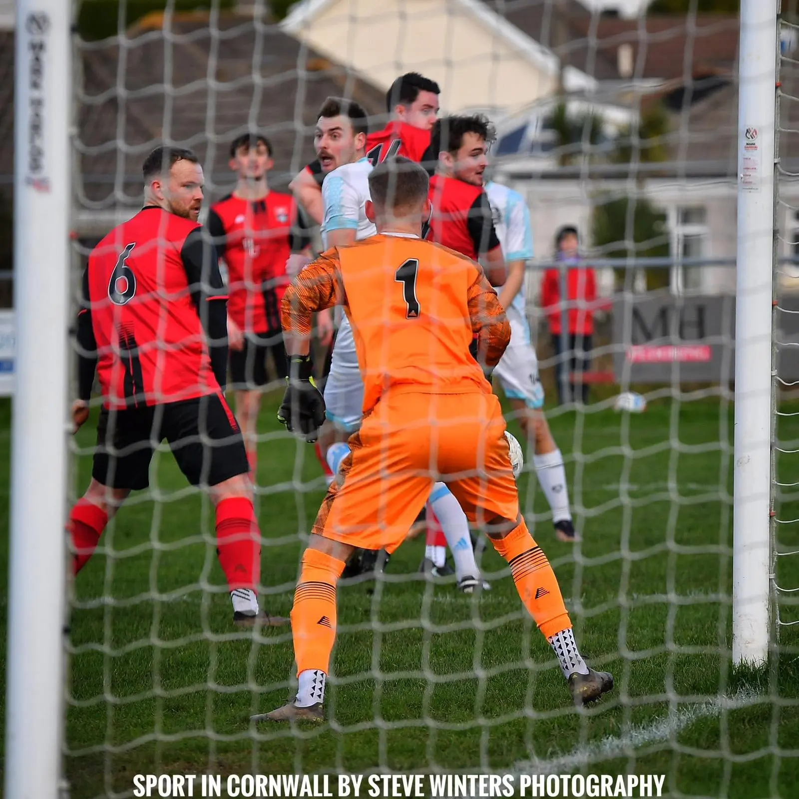 Goalmouth scramble at Clijah Park with the Redruth United keeper and defenders crowding the six-yard box