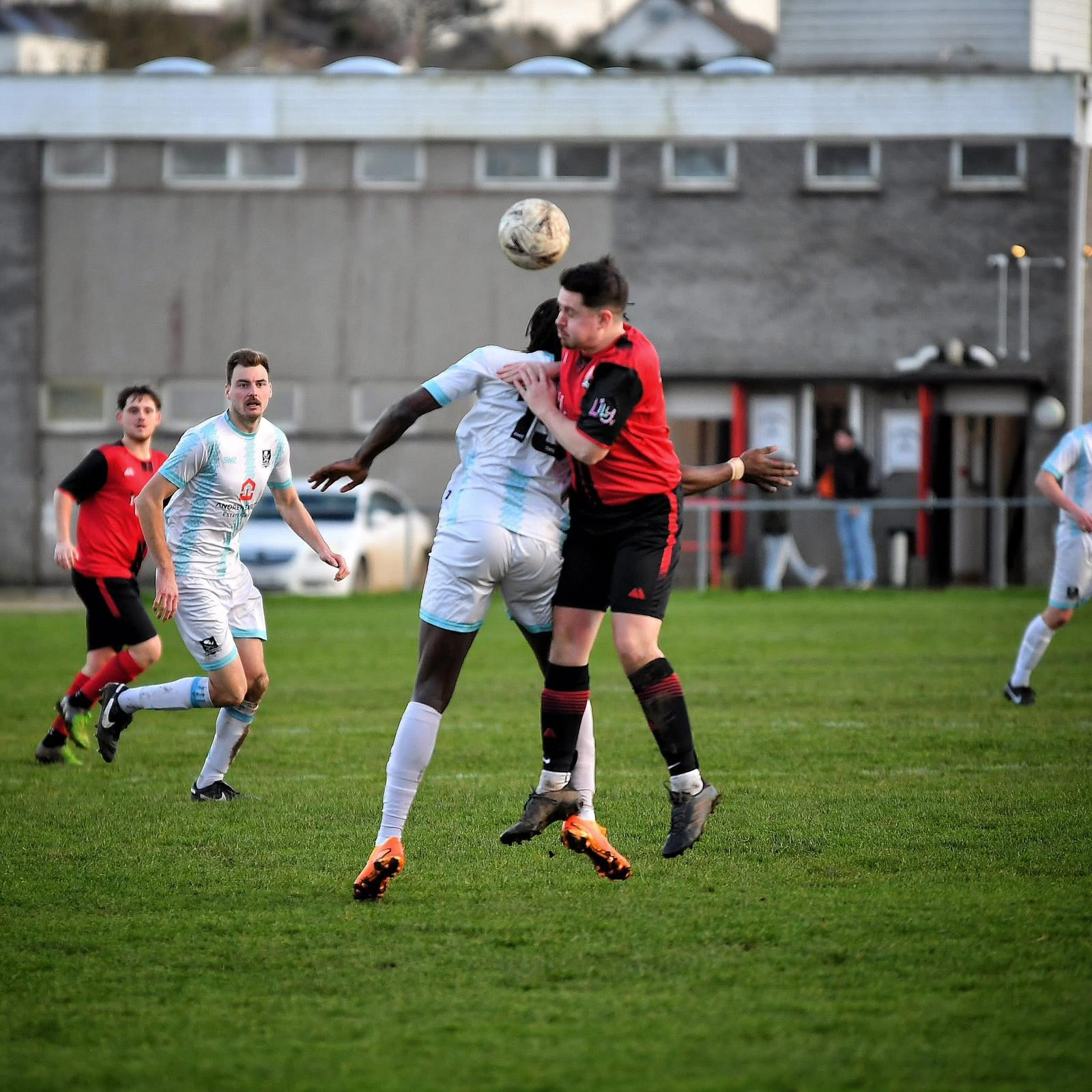 Redruth United men's player winning a header at Clijah Park