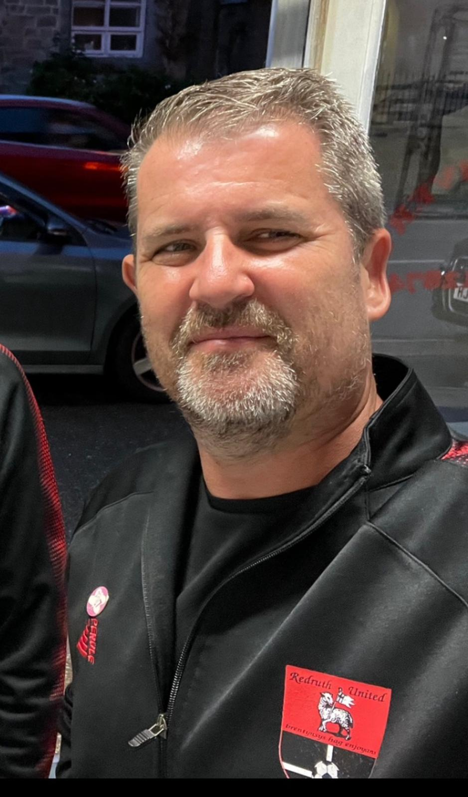 Dale Simkiss, Finance and Business Director, wearing a Redruth United club jacket with the crest